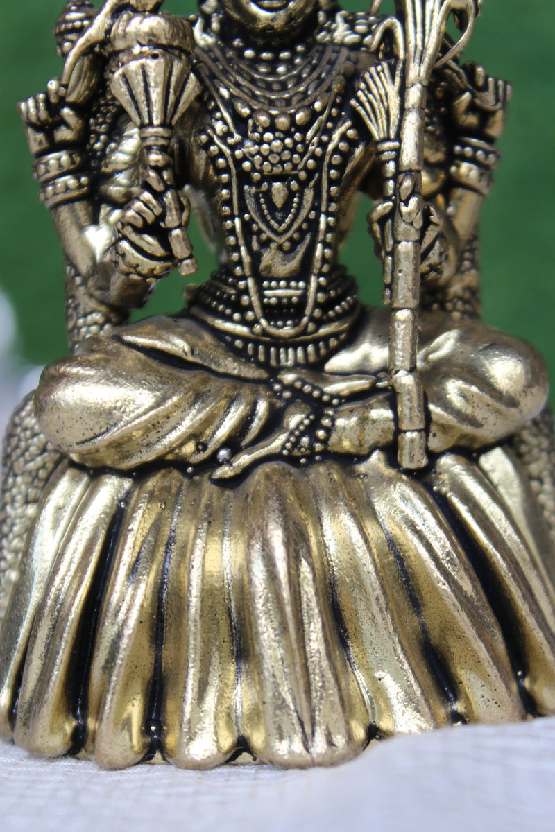 Detailed close-up of Kamakshi Mata brass murti showing four hands holding divine objects, ornate jewellery and lotus base – fine brass craftsmanship