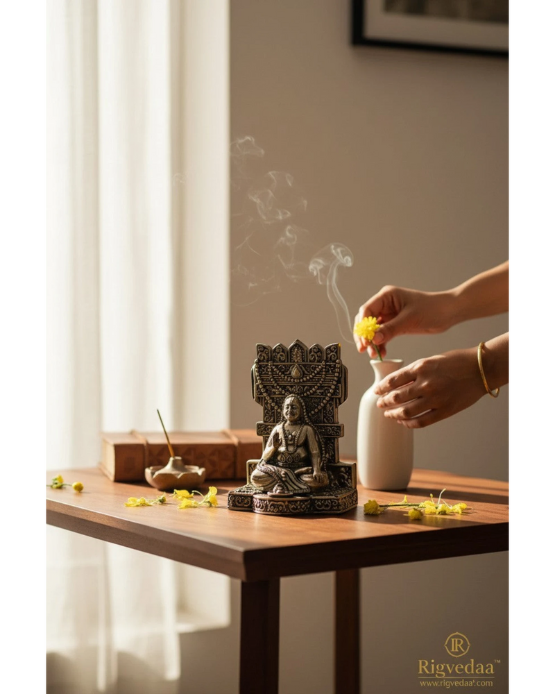 Rigvedaa™ brass idol of Raghavendra Swamy in traditional seated pose with intricate detailing, placed on a wooden table with incense smoke.