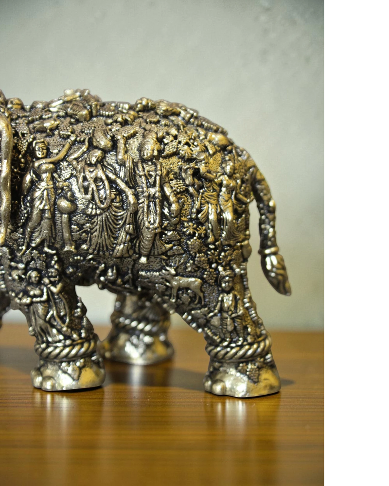 Rigvedaa brass elephant statue with intricate Radha Krishna murals, golden finish, detailed Indian craftsmanship for puja and decor.
