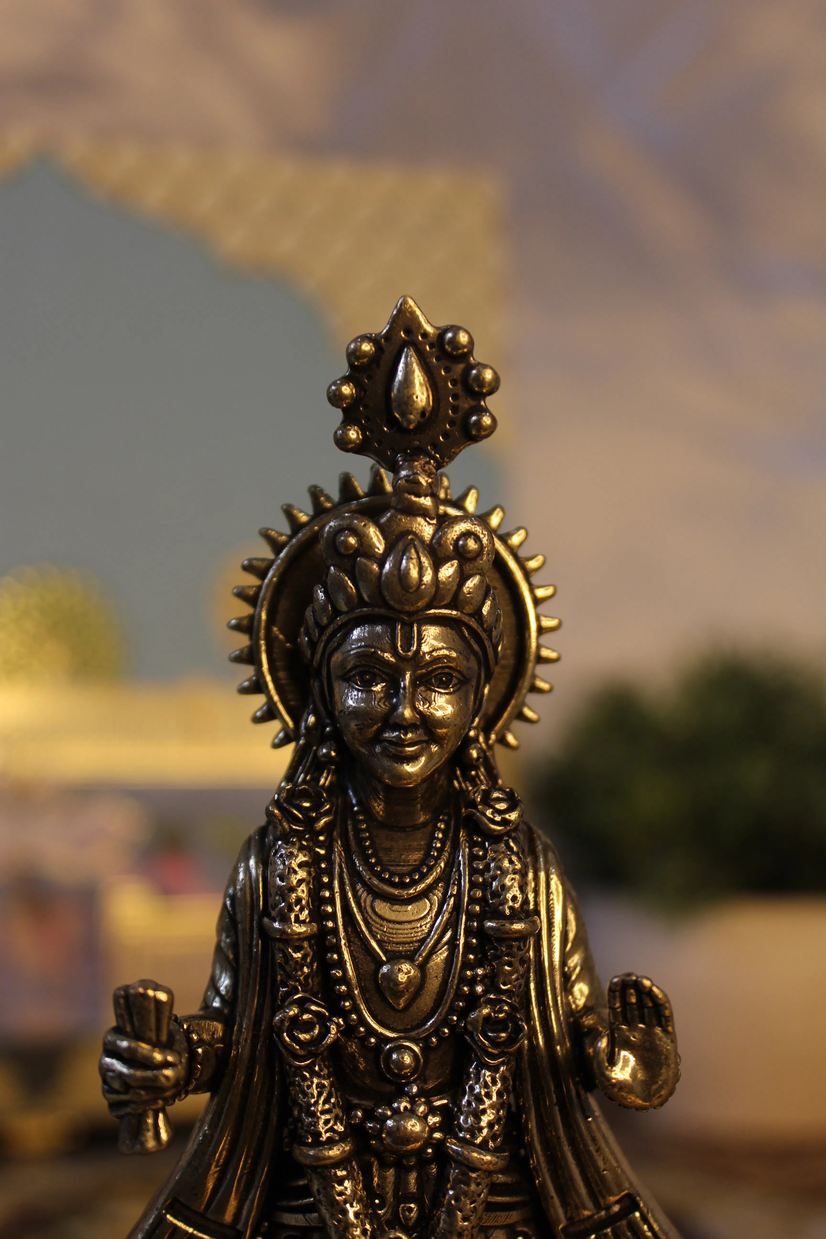 Close-up of brass Narayan Swami face with ornate mukut crown and intricate facial features