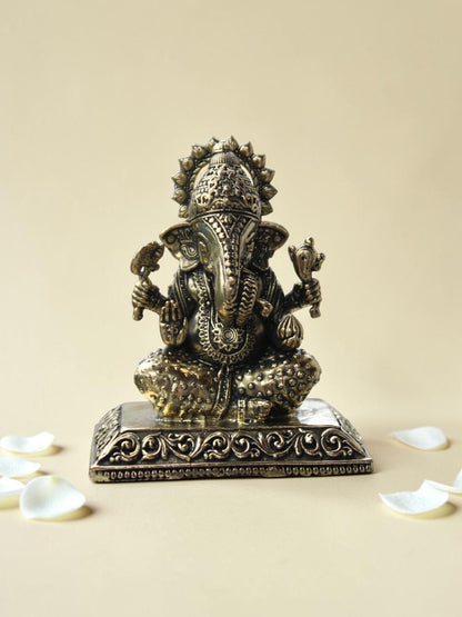 Rigvedaa™ decorative Lord Ganesha idol with an antique gold finish, featuring intricate engravings on a square base.