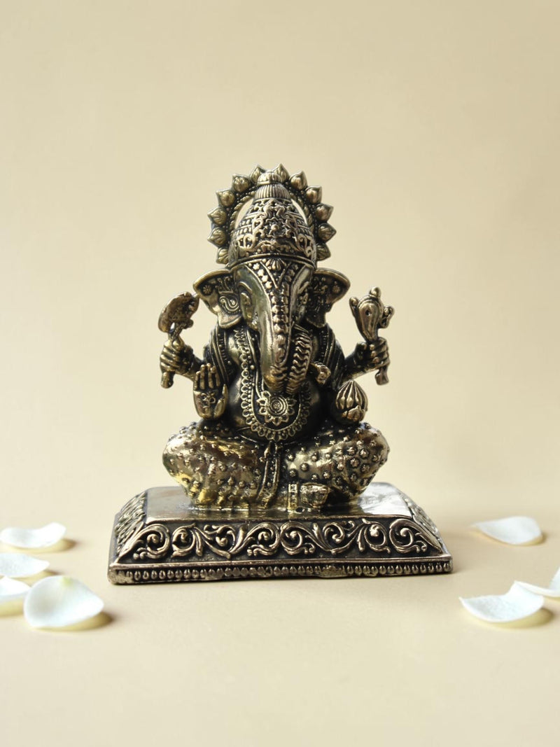Rigvedaa™ decorative Lord Ganesha idol with an antique gold finish, featuring intricate engravings on a square base.
