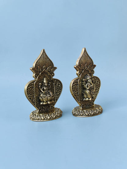Rigvedaa™ antique gold Lakshmi and Ganesha idol set in ornate arch frames with intricate floral and lotus detailing.