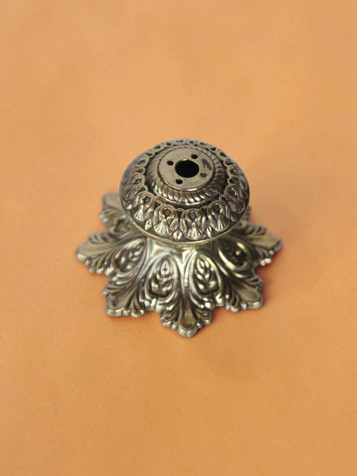 Rigvedaa™ handcrafted solid brass agarbatti stand with an intricate floral petal base and antique golden finish.