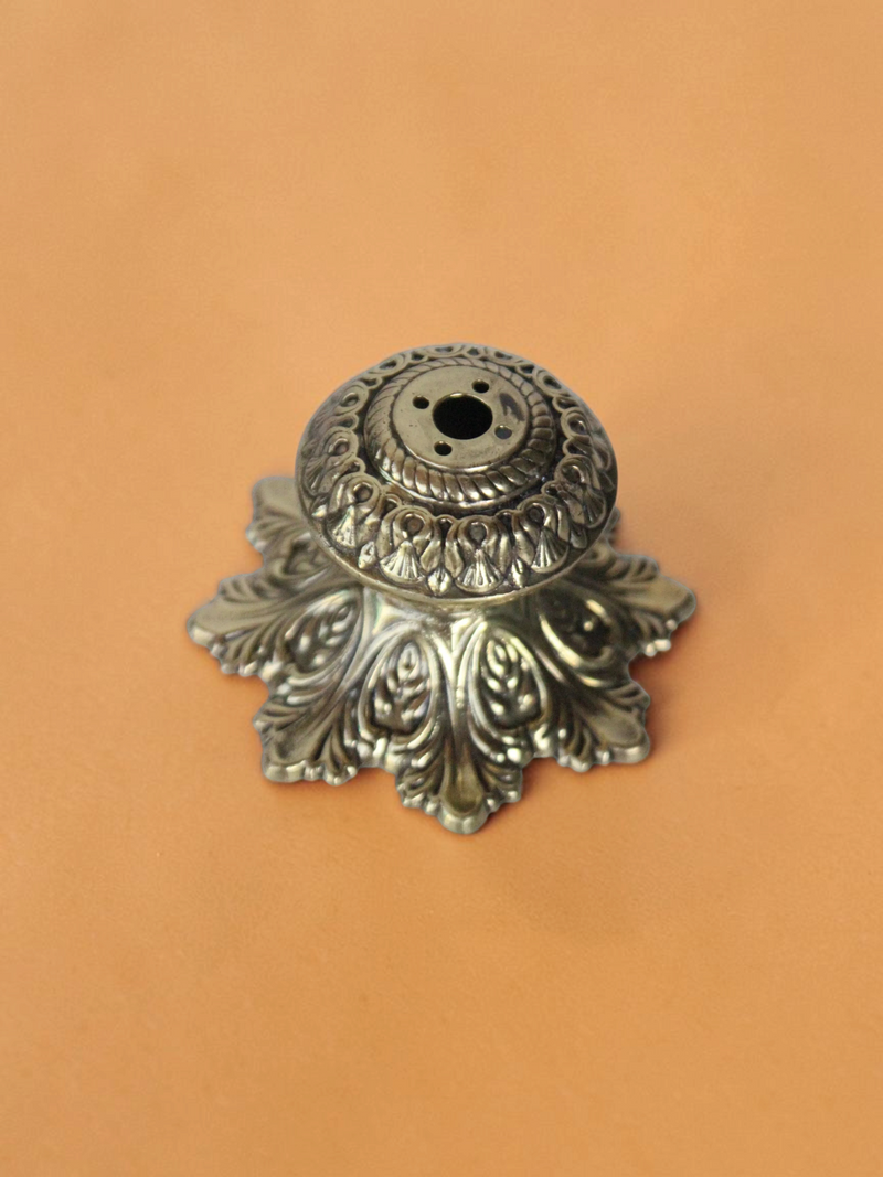 Rigvedaa™ handcrafted solid brass agarbatti stand with an intricate floral petal base and antique golden finish.