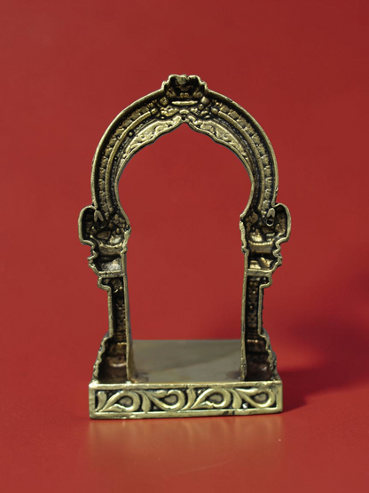 Rigvedaa™ handcrafted brass archway idol stand with intricate scrollwork and a polished golden finish.