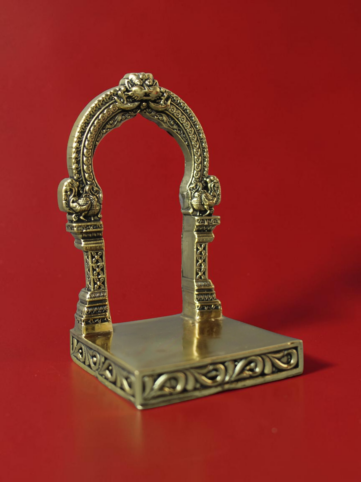 Rigvedaa™ handcrafted brass archway idol stand with intricate ornate carvings and a polished golden finish