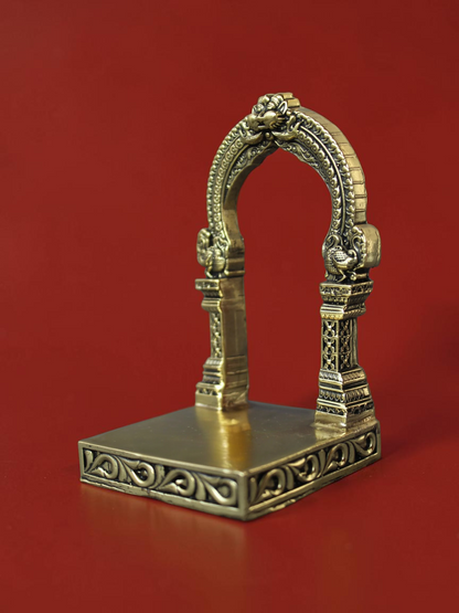 Rigvedaa™ handcrafted brass archway idol stand with intricate carvings and ornate scrollwork on a square base