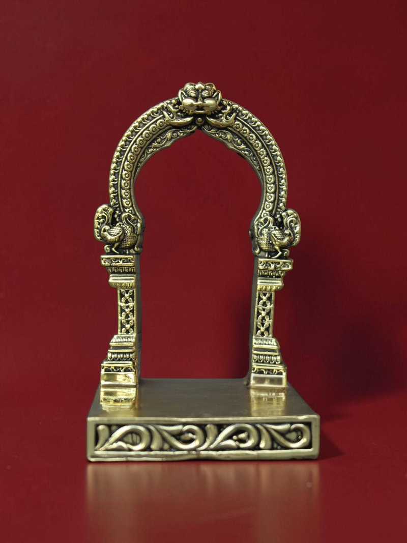 Rigvedaa™ decorative brass archway idol stand with intricate carvings and ornate peacock motifs on a flat base