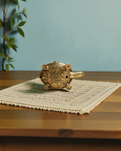Rigvedaa	rade	rade brass tortoise with Shree Yantra and Ashta Lakshmi carvings, golden patina, intricate details.