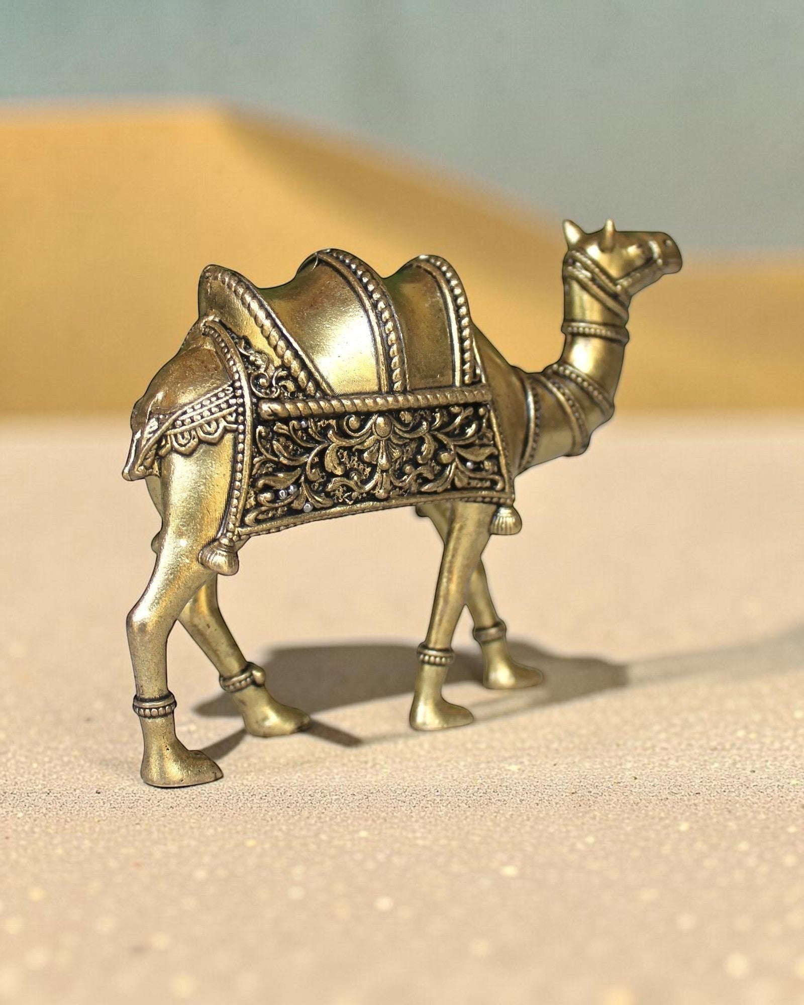 Rigvedaa™ brass desert camel statue with intricate traditional saddle detailing and golden finish, symbol of Rajasthani heritage.