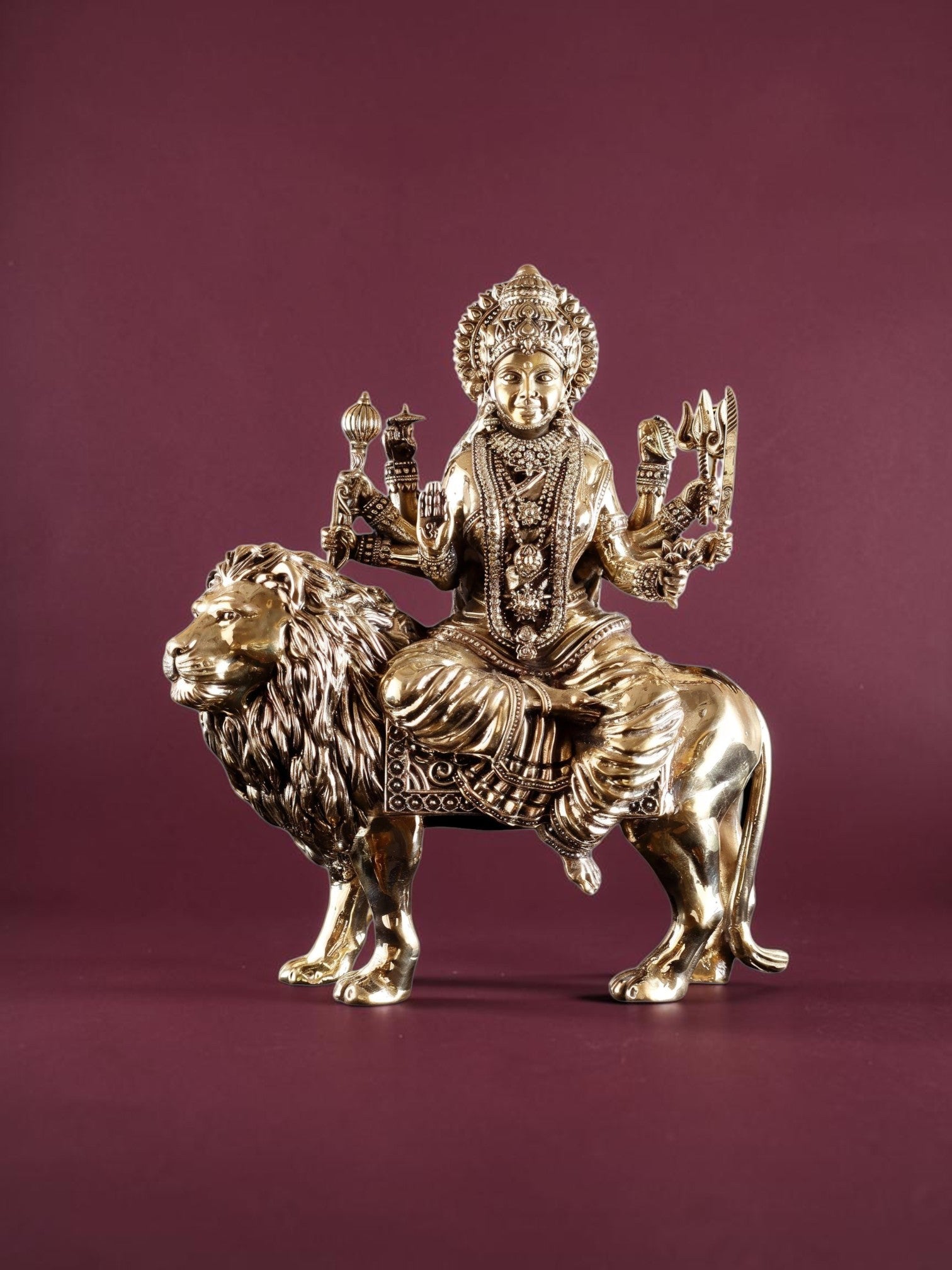 Rigvedaa™ 12-inch brass Goddess Durga statue seated on a lion, featuring intricate detailing and golden patina finish.