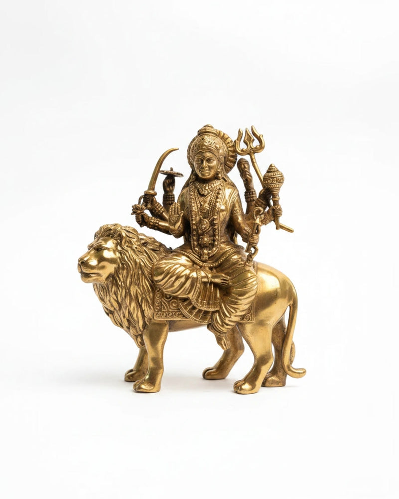 Rigvedaa brass Durga seated on lion murti, holding weapons and in abhaya mudra. Golden patina.