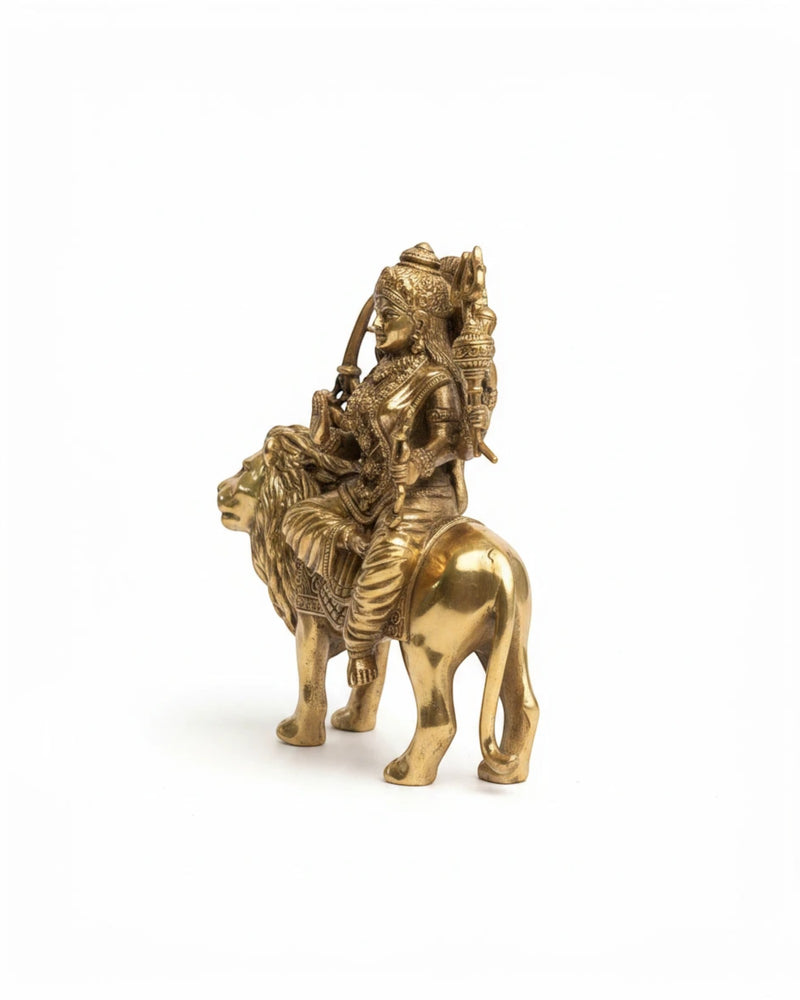 Rigvedaa™ brass Durga seated on lion murti with multiple arms, holding weapons, in Abhaya Mudra. Golden patina.