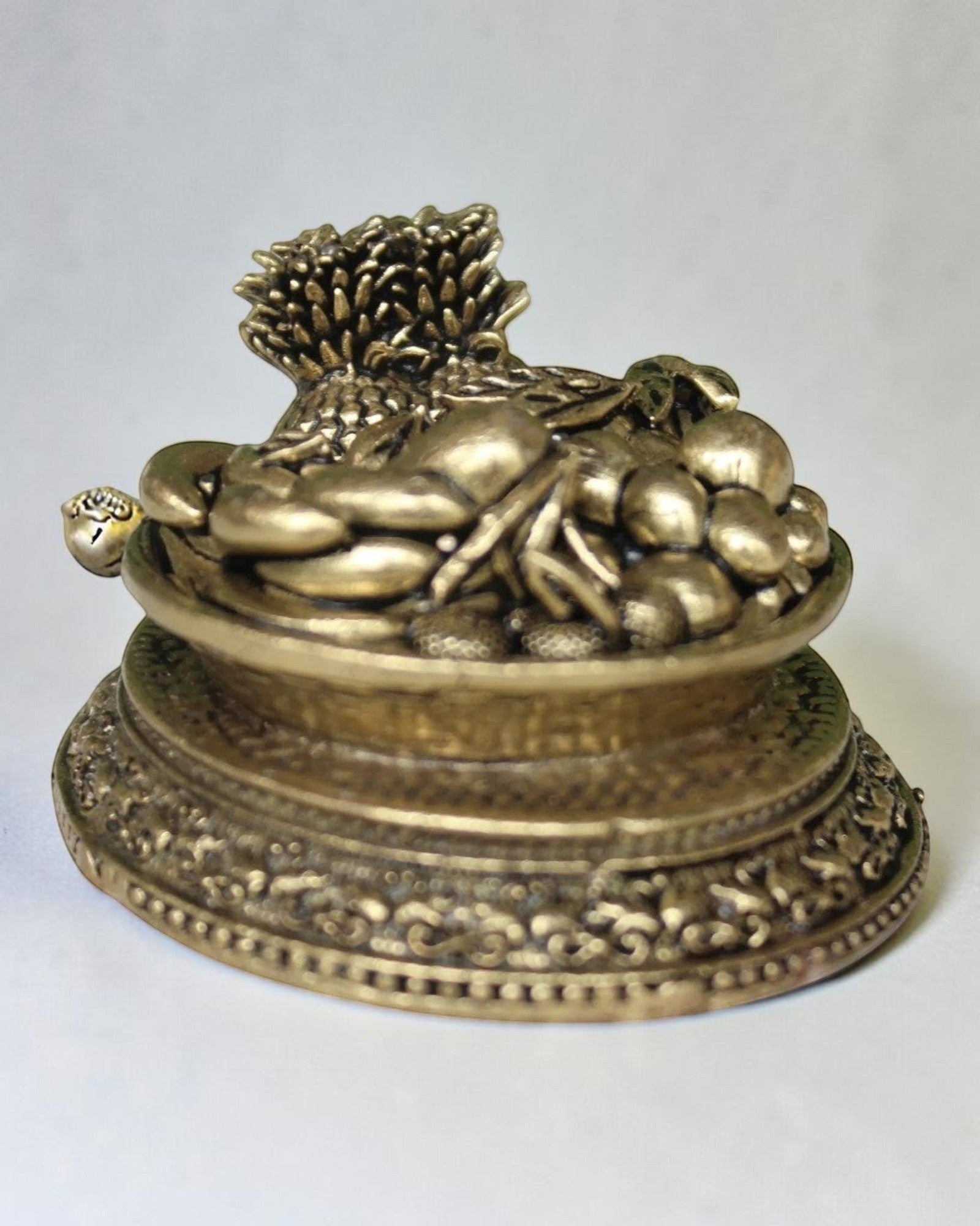 Rigvedaa™ antique brass miniature fruit basket idol with ornate pedestal base, symbolizing abundance and prosperity.