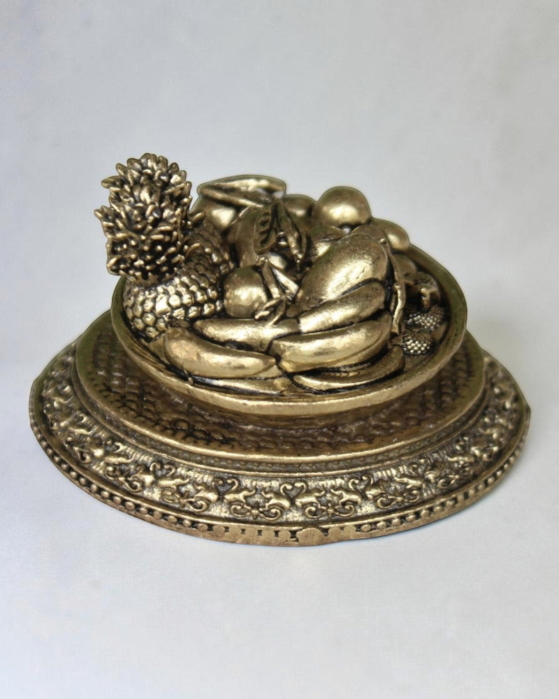 Rigvedaa™ antique gold brass miniature fruit basket idol with pineapple, grapes, and other fruits on an ornate pedestal base. Symbolizes prosperity and abundance.