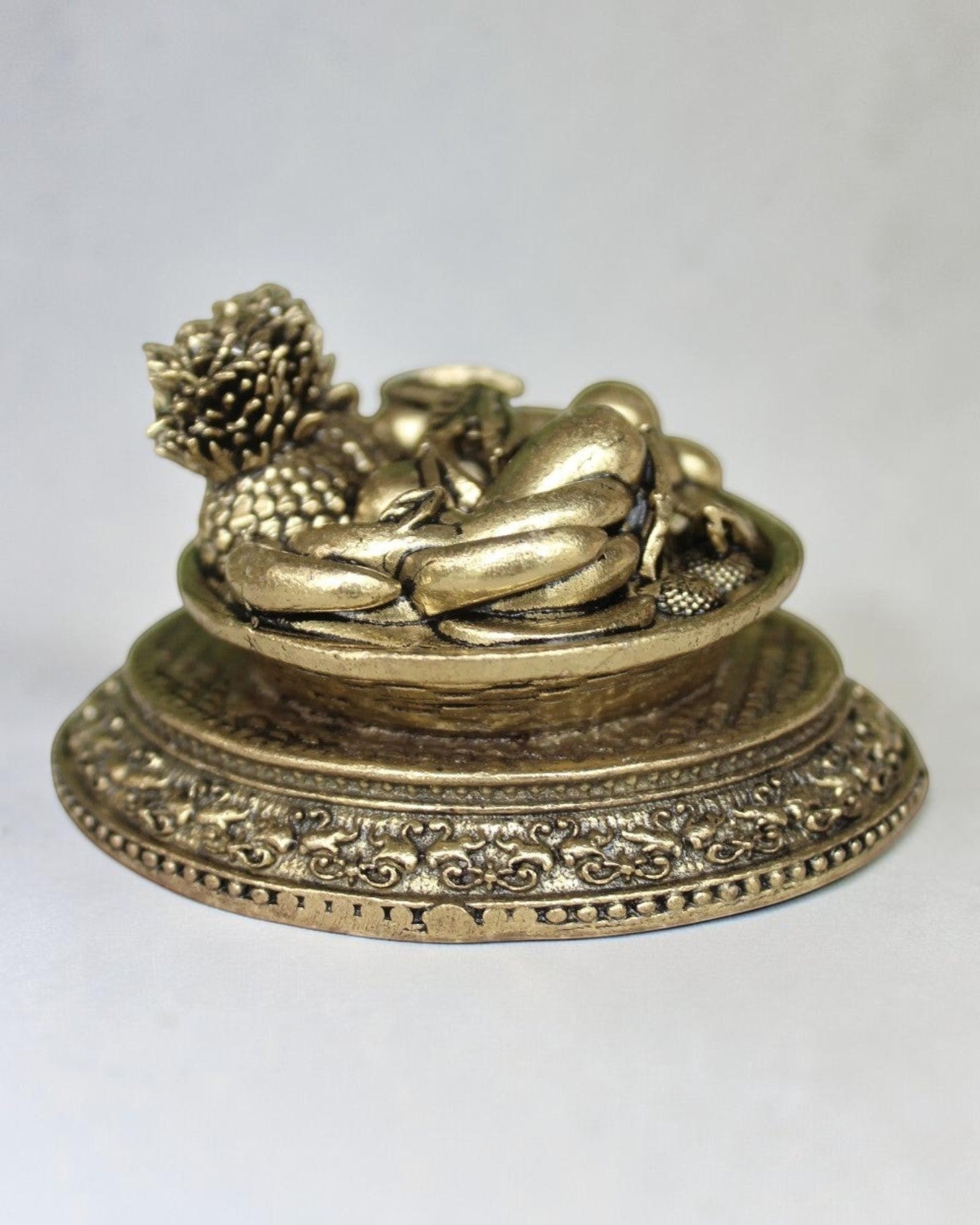 Rigvedaa™ brass miniature fruit basket idol with ornate pedestal base, antique golden finish, symbolising prosperity and abundance.