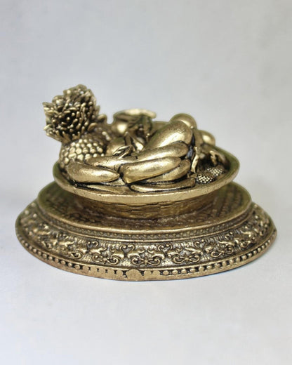 Rigvedaa™ brass miniature fruit basket idol with ornate pedestal base, antique golden finish, symbolising prosperity and abundance.