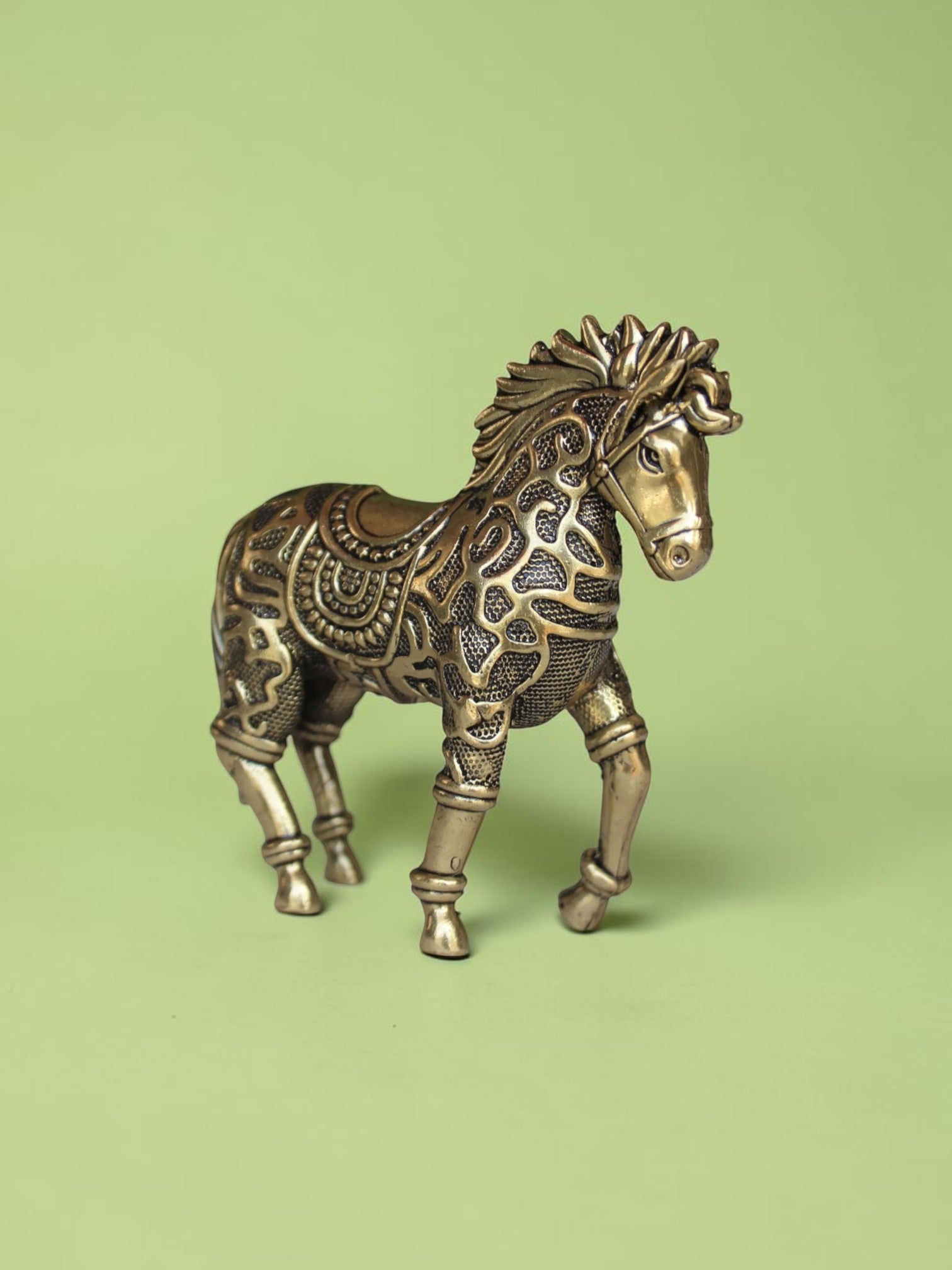 Rigvedaa™ 3.75-inch brass galloping horse statue with intricate traditional relief patterns and a warm golden patina.