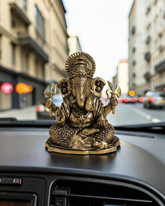 Rigvedaa™ brass Ganesha idol for car dashboard, detailed golden finish, seated pose with four arms holding symbolic items.