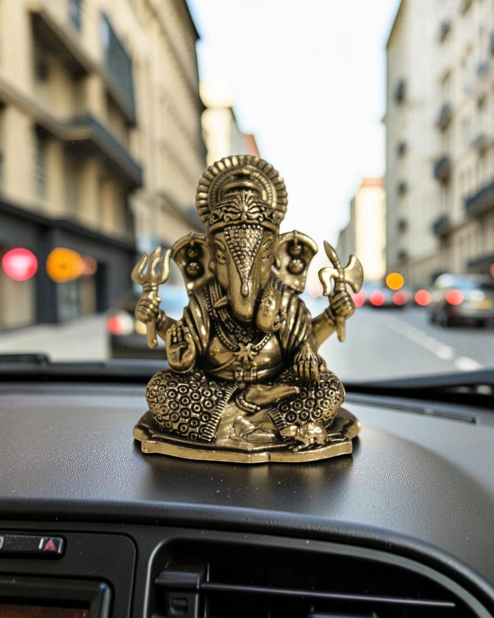 Rigvedaa™ brass Ganesha idol for car dashboard, seated with detailed ornamentation and holding symbolic items.