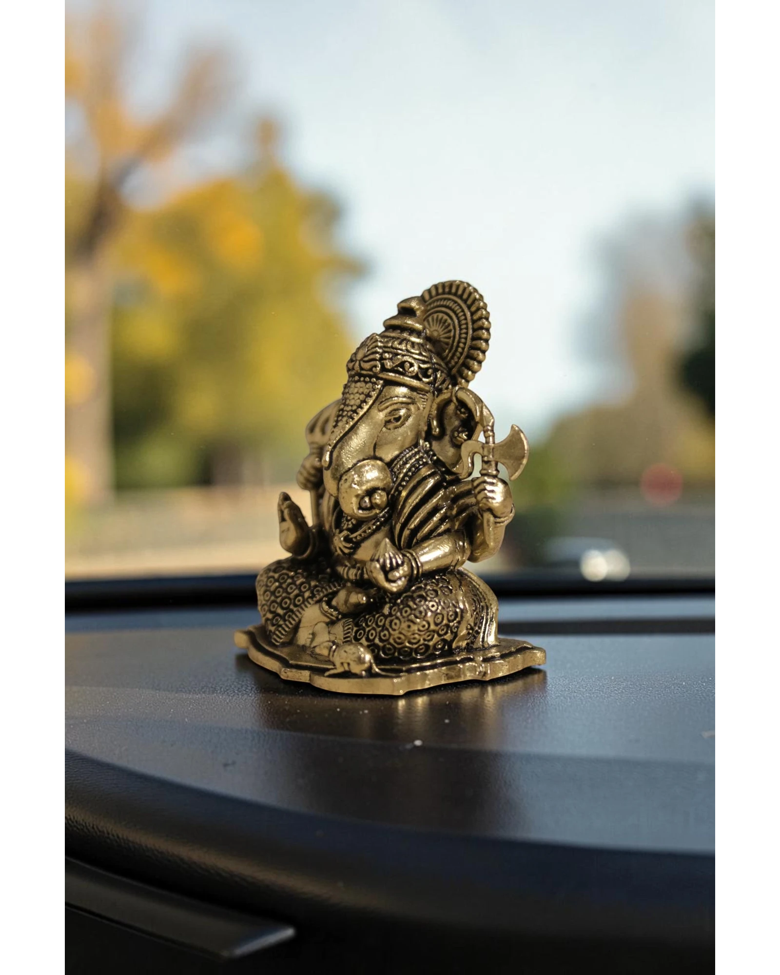 Rigvedaa™ brass Ganesha idol for car dashboard, detailed golden finish, seated pose, for good luck and protection.