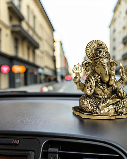 Rigvedaa™ brass Ganesha idol for car dashboard, detailed golden finish, holding trident, for good luck and protection.