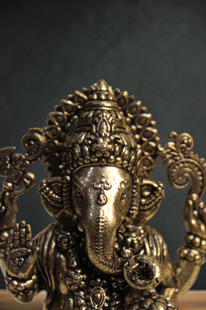 Rigvedaa™ brass Lord Ganesha idol seated on a lotus, 4-inch, golden finish, holding symbolic items.