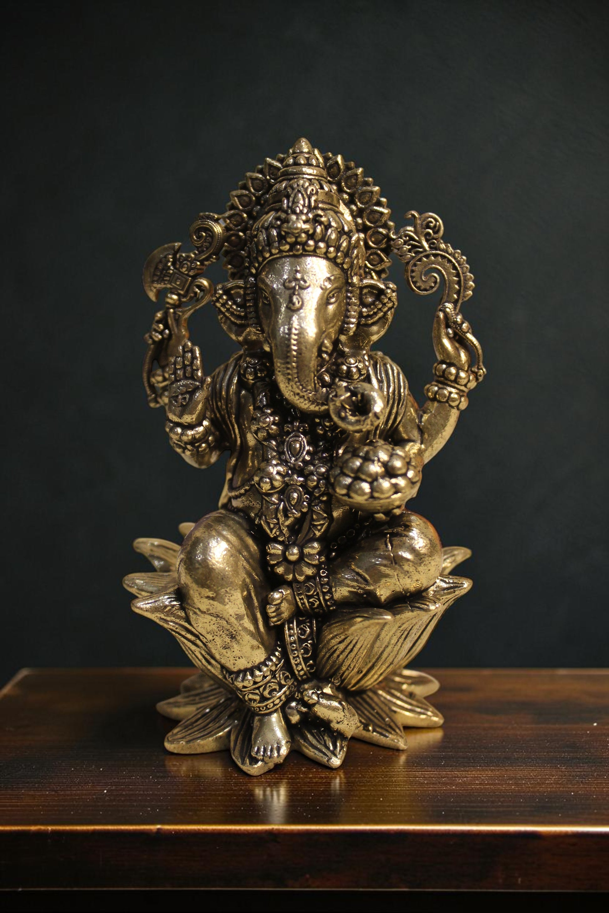 Rigvedaa™ brass Lord Ganesha idol seated on a lotus pedestal, 4-inch, golden finish, holding sacred items.