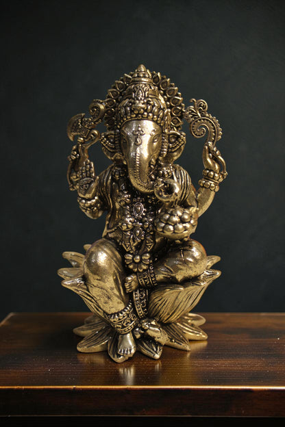 Rigvedaa™ brass Lord Ganesha idol seated on a lotus pedestal, 4-inch, golden finish, holding sacred items.