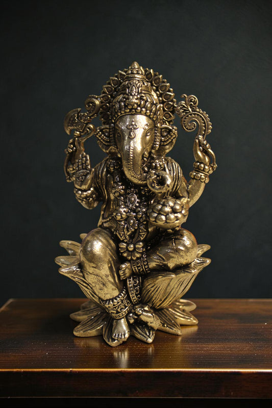 Rigvedaa™ brass Lord Ganesha idol seated on a lotus pedestal, 4-inch, golden finish, holding sacred items.