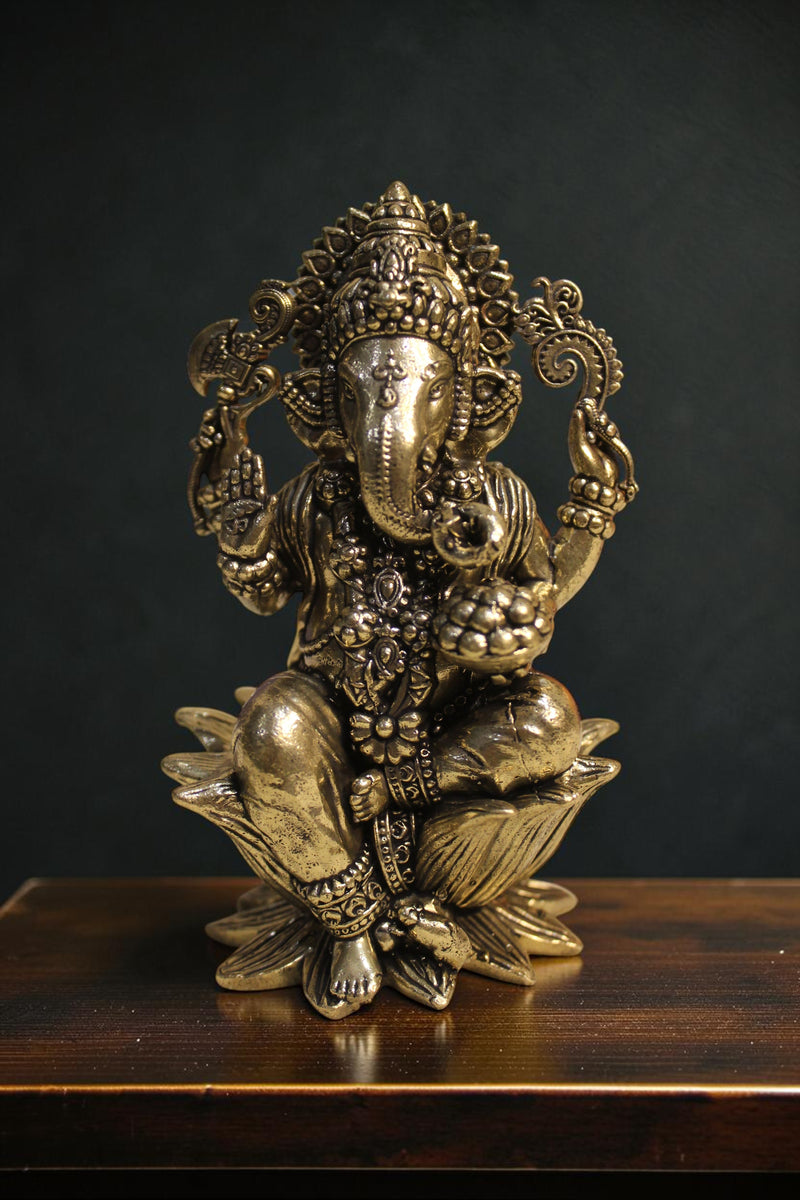 Rigvedaa™ brass Lord Ganesha idol seated on a lotus pedestal, 4-inch, golden finish, holding sacred items.