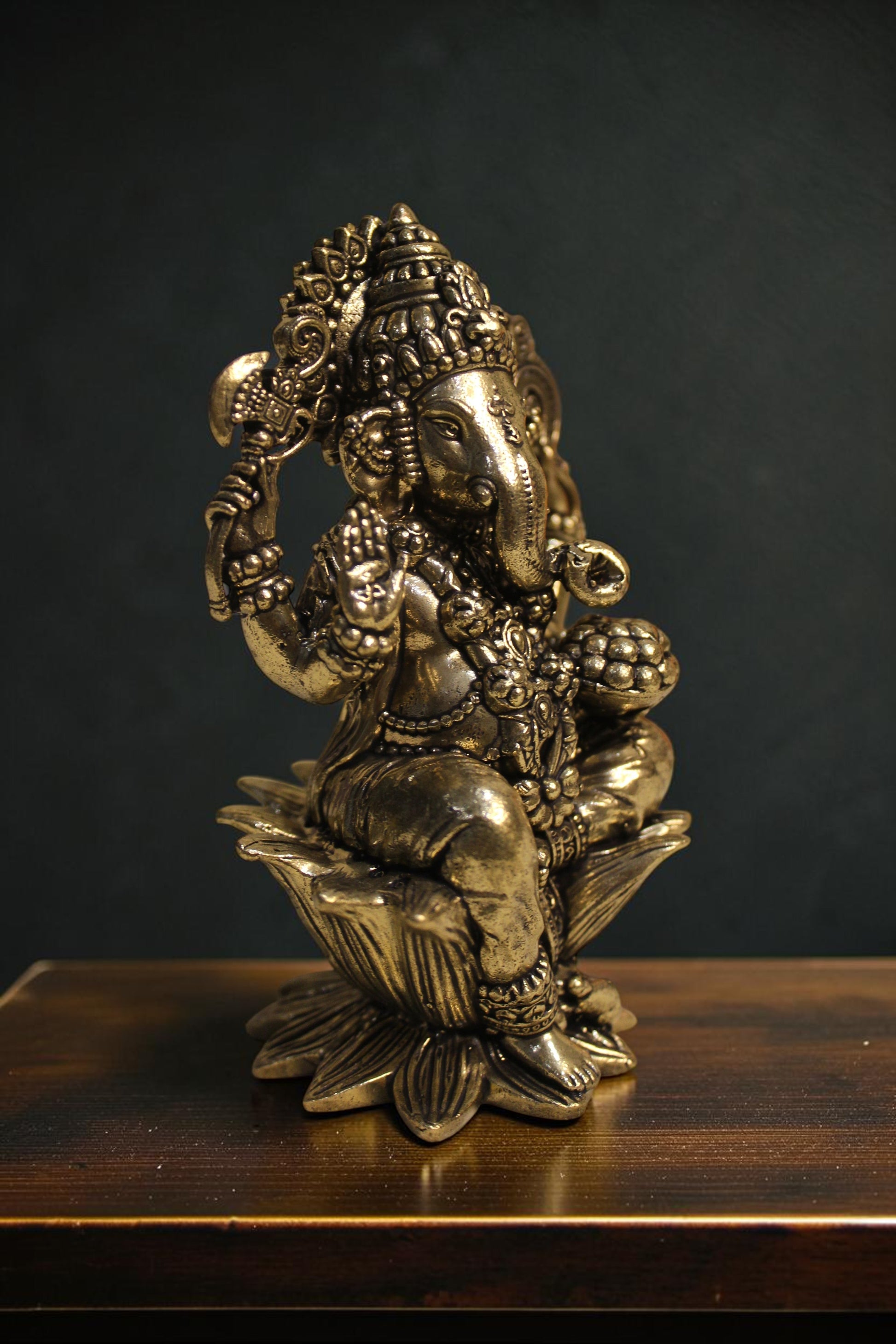 Rigvedaa™ Brass Lord Ganesha idol seated on a lotus pedestal, 4-inch golden sculpture with intricate details, holding traditional items.