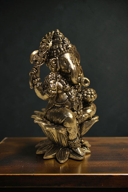 Rigvedaa™ Brass Lord Ganesha idol seated on a lotus pedestal, 4-inch golden sculpture with intricate details, holding traditional items.