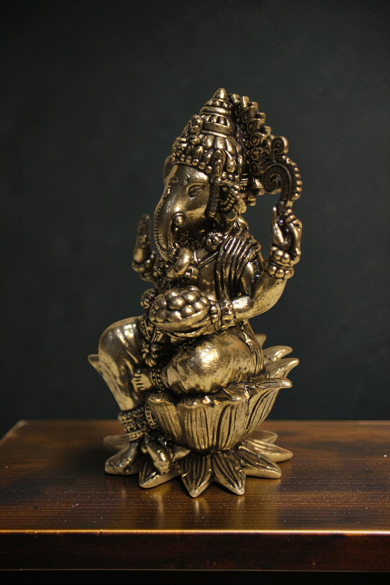 Rigvedaa™ Brass Lord Ganesha idol seated on a lotus pedestal, 4-inch golden divine sculpture for wisdom and prosperity.