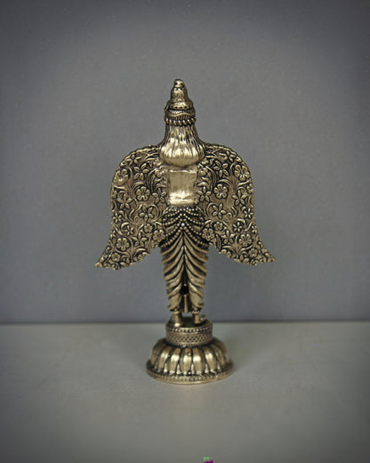 Rigvedaa brass Garuda statue with spread wings, intricate floral patterns, and antique gold finish. Ideal for pooja and home decor.