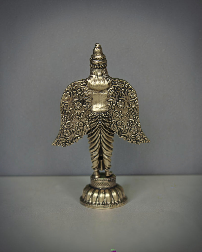 Rigvedaa brass Garuda statue with spread wings, intricate floral patterns, and antique gold finish. Ideal for pooja and home decor.
