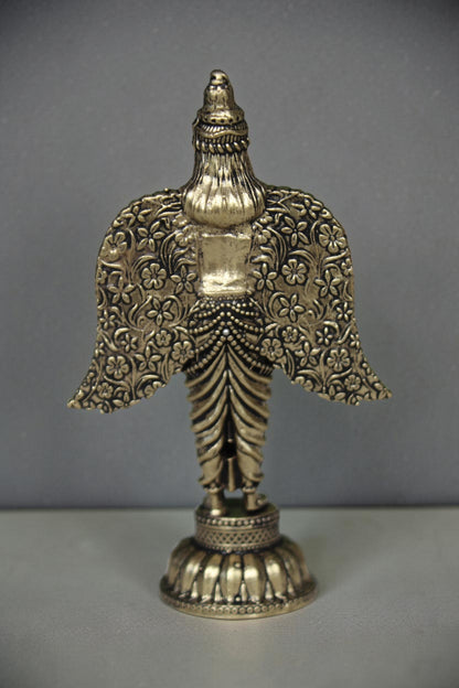 Rigvedaa brass Garuda statue with spread wings, intricate floral patterns, and antique gold finish. Ideal for pooja and home decor.