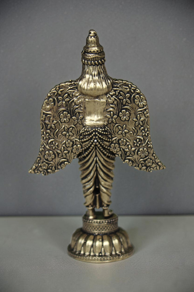 Rigvedaa brass Garuda statue with spread wings, intricate floral patterns, and antique gold finish. Ideal for pooja and home decor.