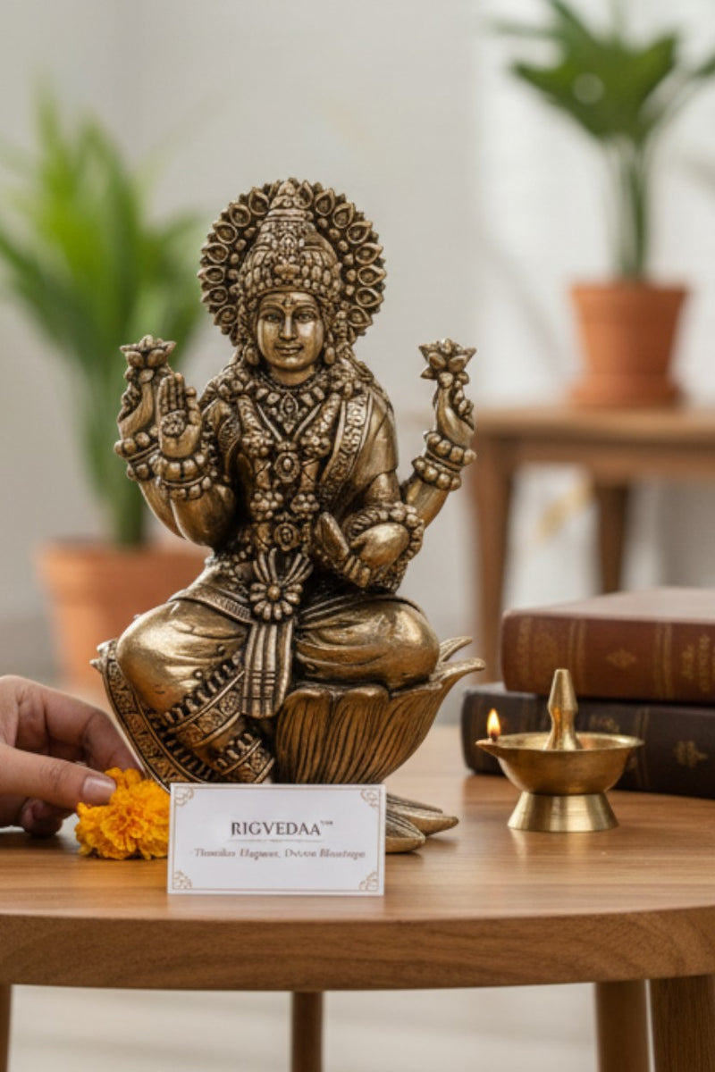 Rigvedaa brass Goddess Lakshmi idol seated on a lotus, holding flowers and coins. Golden finish, intricate details. 4-inch divine sculpture for abundance.