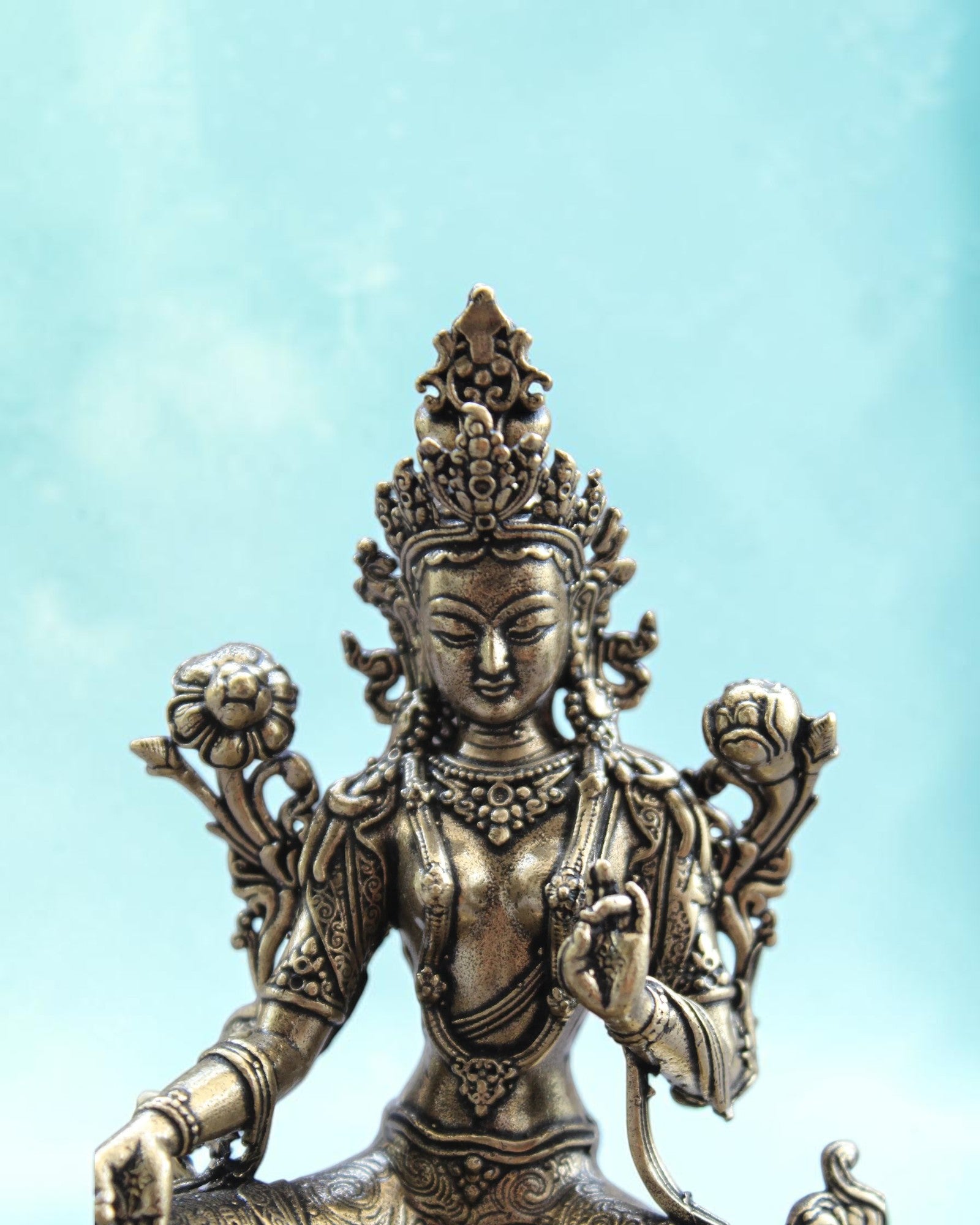 Rigvedaa™ brass statue of seated Goddess Tara in Varada Mudra, holding a lotus, detailed crown and jewelry, golden patina.