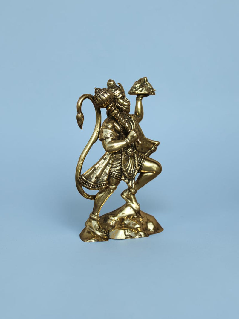 Rigvedaa™ polished brass Lord Hanuman idol holding the Dronagiri mountain and mace on a light blue background.