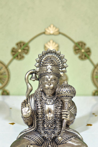 Rigvedaa™ brass Hanuman Ji idol sitting on a throne, holding a mace and bell, with intricate detailing.