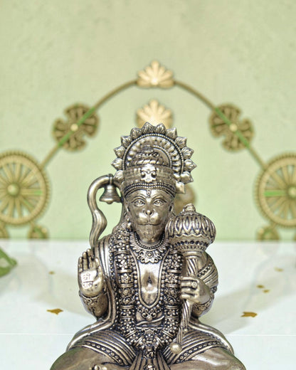 Rigvedaa™ brass Hanuman Ji idol sitting on a throne, holding a mace and bell, with intricate detailing.