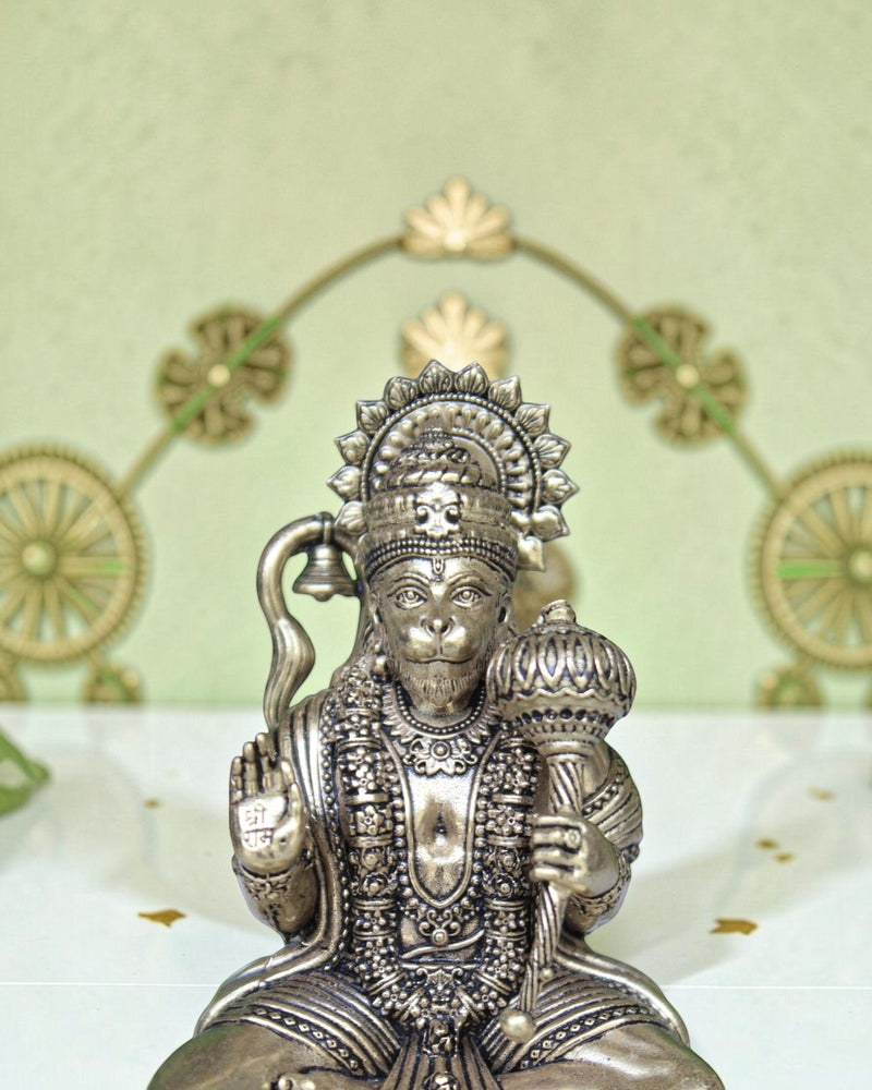 Rigvedaa™ brass Hanuman Ji idol sitting on a throne, holding a mace and bell, with intricate detailing.