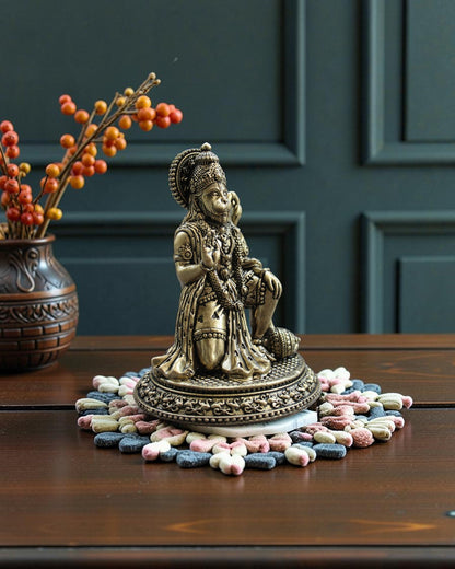 Rigvedaa™ Brass Hanuman Ji statue in blessing pose, seated with mace, detailed traditional attire and warm golden patina.