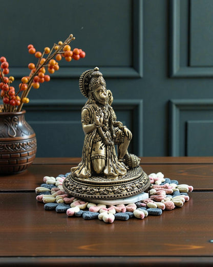Rigvedaa™ Brass Hanuman Ji statue in blessing pose, seated with mace, detailed traditional attire and warm golden patina.
