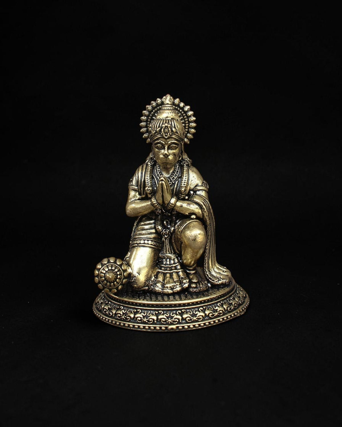 Rigvedaa™ handcrafted brass Hanuman statue in a kneeling prayer pose with intricate detailing and a warm golden patina.
