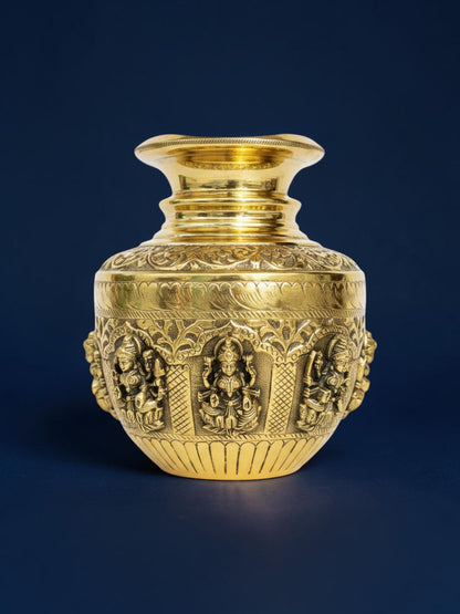 Rigvedaa™ handcrafted brass kalash pot with intricate embossed deity carvings and a polished gold-tone finish.