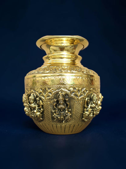Rigvedaa™ handcrafted brass kalash pot with intricate embossed deity carvings and a polished gold-tone finish.